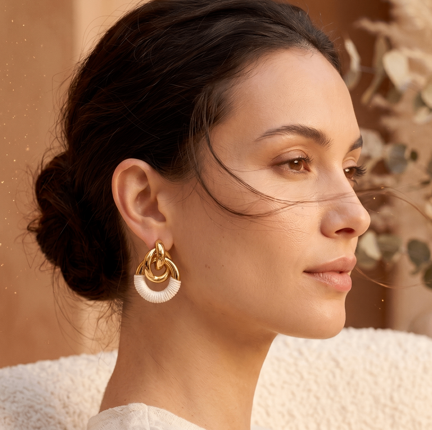 Modèle AVA portant des boucles d'oreilles dans un décor floral